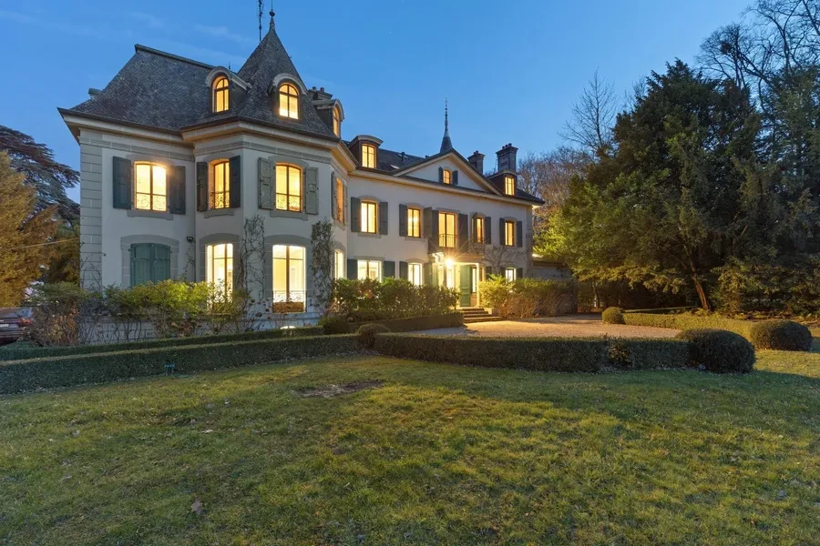 Historic Geneva estate Choulex — ground-level view of the manor façade with mature trees and private grounds