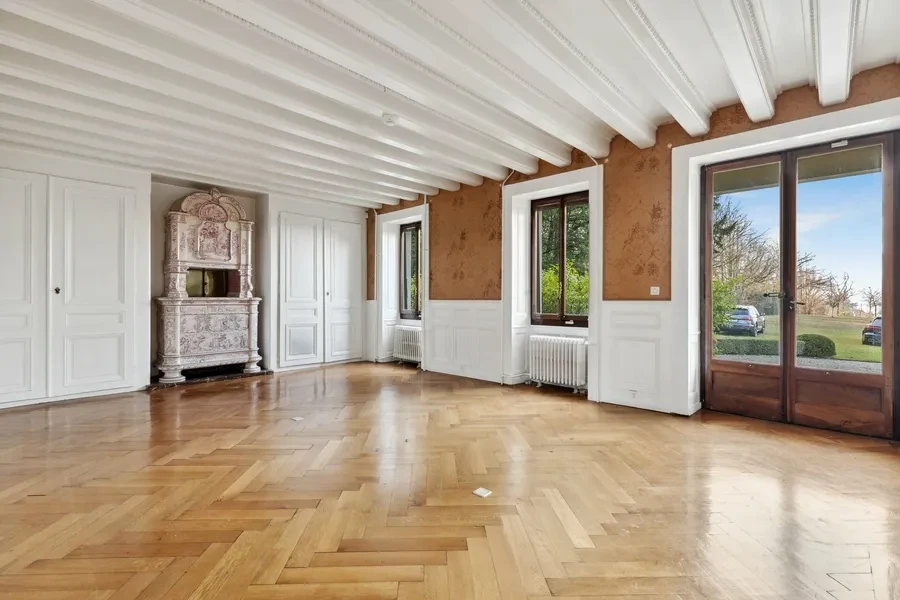 Historic Geneva estate Choulex — grand reception room with herringbone parquet floors and period fireplace