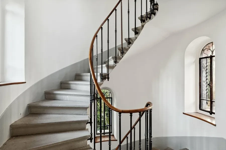 Historic Geneva estate Choulex — original curved marble staircase with ornate wrought-iron balustrade