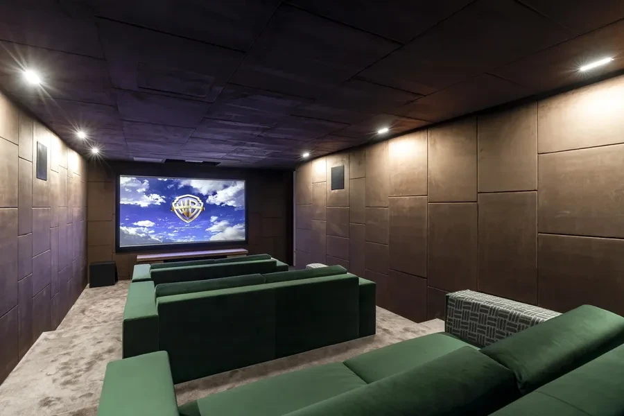 Cologny Geneva contemporary villa — professional home cinema with green velvet seating and acoustic panelling