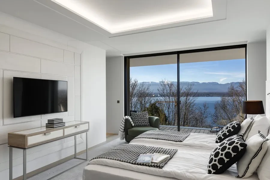 Cologny Geneva contemporary villa — principal bedroom suite with floor-to-ceiling glazing and panoramic Lake Geneva views