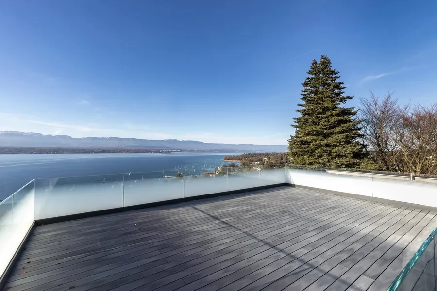 Cologny Geneva contemporary villa — rooftop terrace with glass balustrade and sweeping panoramic views over Lake Geneva