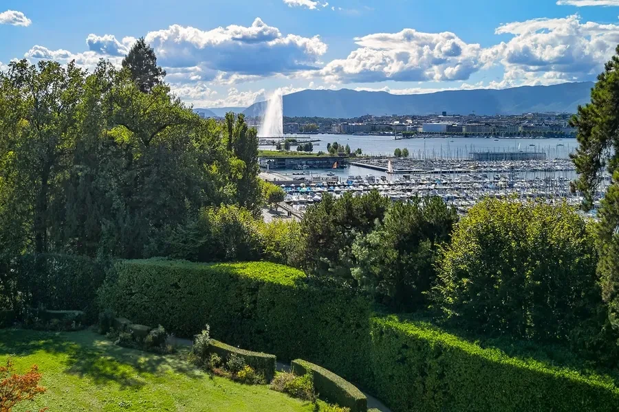 Cologny Geneva historic manor estate — landscaped garden terrace with panoramic views over Lake Geneva and the Jet d'Eau
