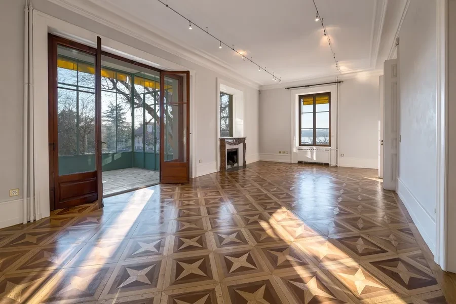 Cologny Geneva historic manor estate — reception room with marquetry parquet, fireplace and lake views through tall windows
