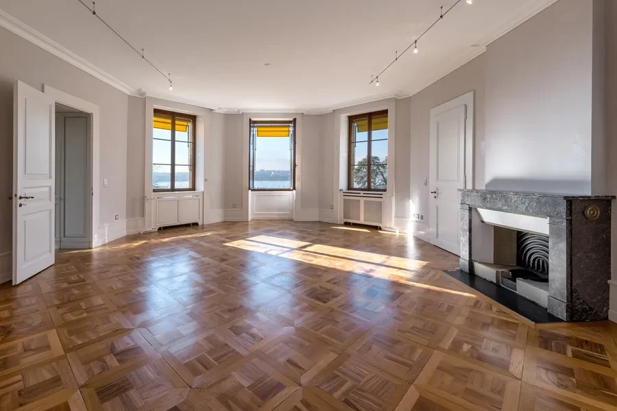 Cologny Geneva historic manor estate — elegant salon with herringbone parquet floors, marble fireplace and lake views