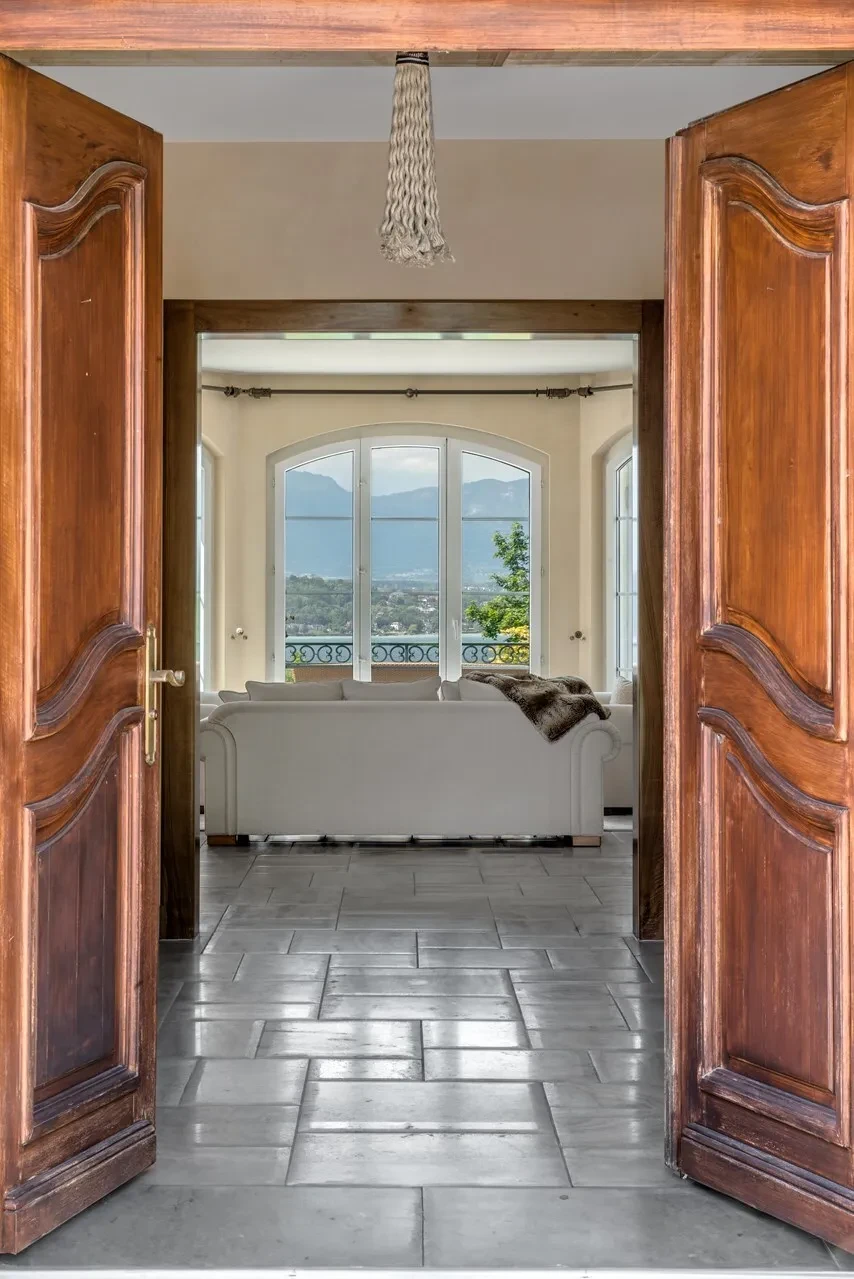 Domaine de Port-Noir Cologny Geneva — grand double entrance doors in carved walnut opening to the principal salon with lake views