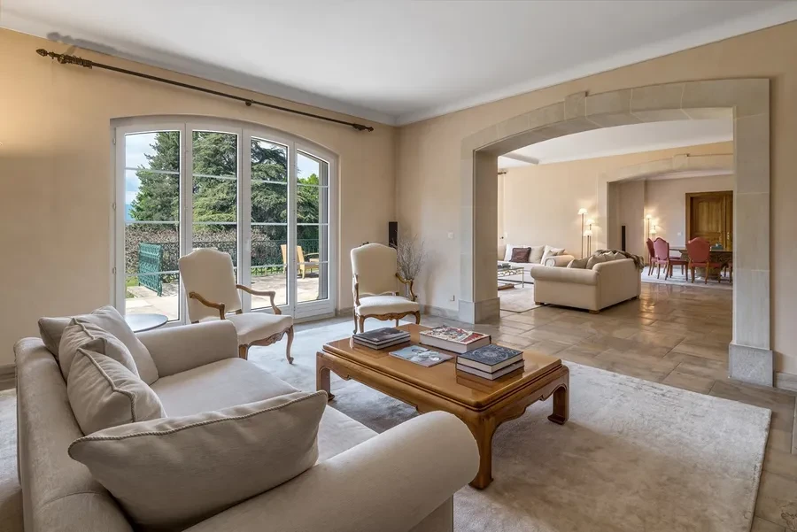 Domaine de Port-Noir Cologny Geneva — reception salon with stone arched doorway, limestone floors and garden views