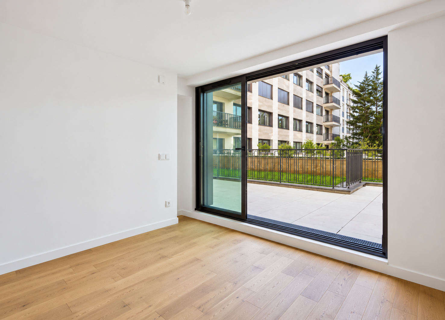 Bright room with floor-to-ceiling sliding doors opening to private terrace