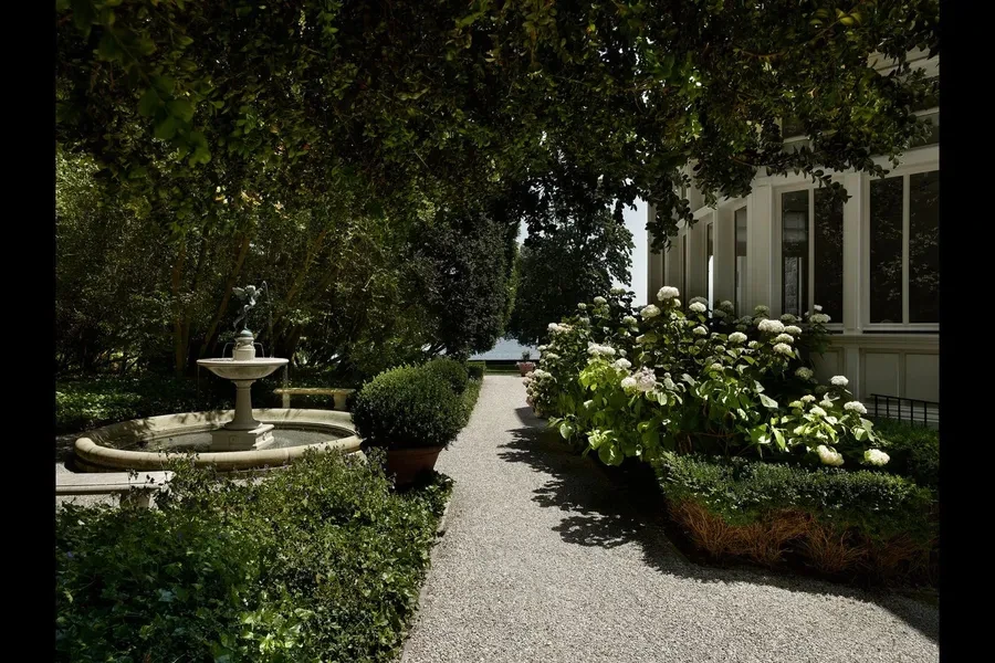 Garden path with stone fountain and hydrangeas beside the manor