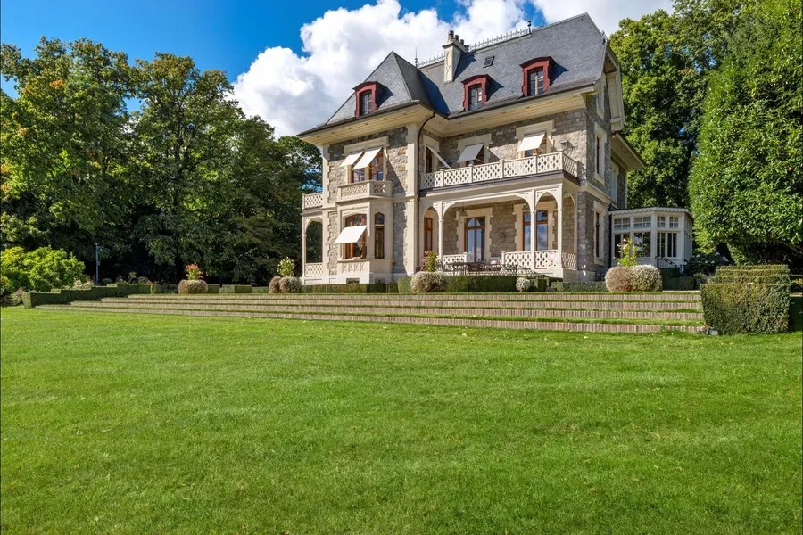 Manor house facade with manicured lawn and terraced gardens