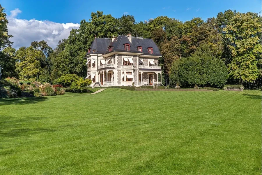 Manor house from the grounds with mature trees and lawns