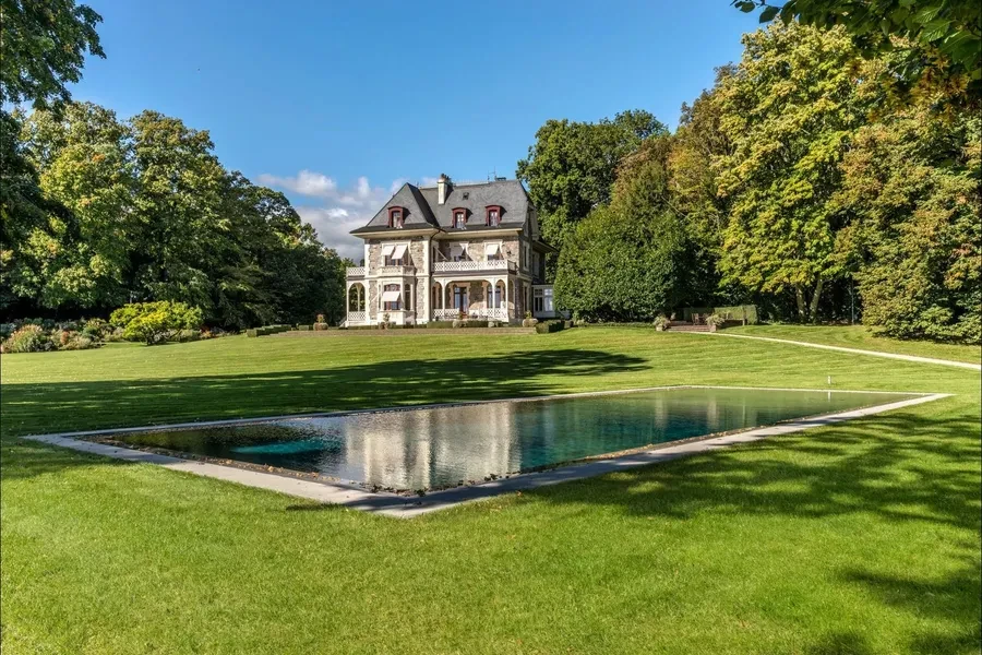 Manor house from grounds with pool reflection