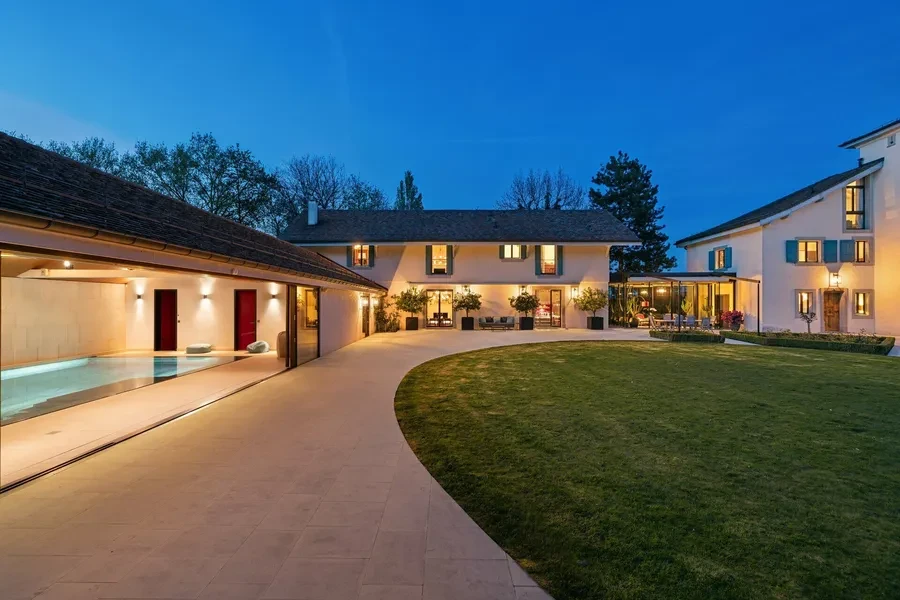 Historic château courtyard with heated indoor pool at dusk, Canton of Geneva