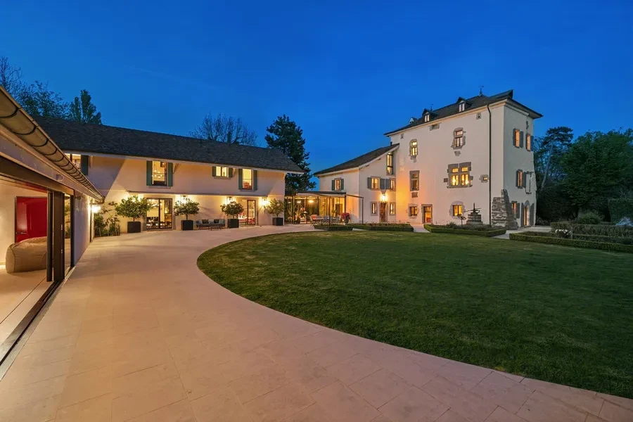 Historic château courtyard and grounds illuminated at evening