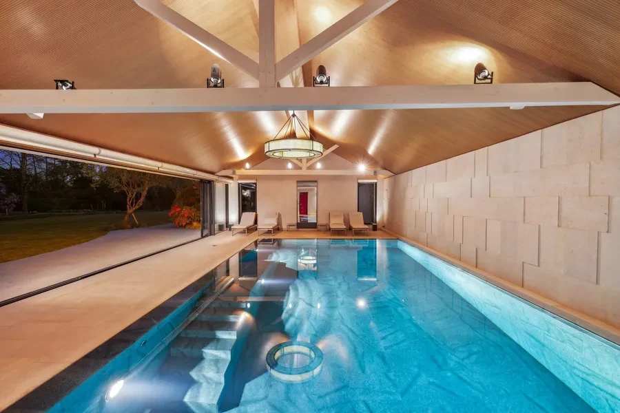 Heated indoor swimming pool with vaulted ceiling opening to the exterior