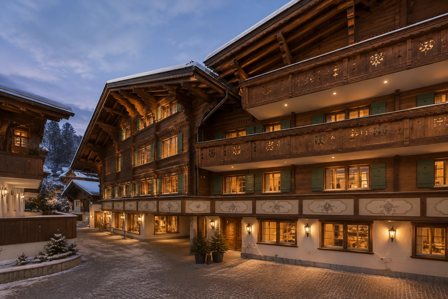 Résidence chalet traditionnelle au centre de Gstaad au crépuscule avec éclairage chaleureux