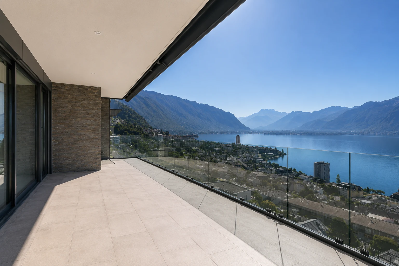 Grande terrasse avec garde-corps en verre offrant une vue panoramique époustouflante sur le lac Léman, Montreux et les Alpes depuis une villa contemporaine exceptionnelle